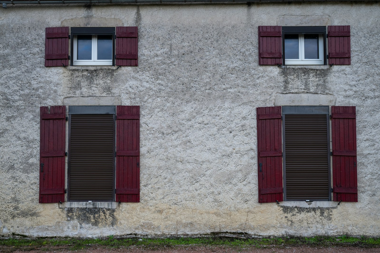 Fenêtres avec volets fermés sur une façade, technique pour garder une maison au frais sans climatisation